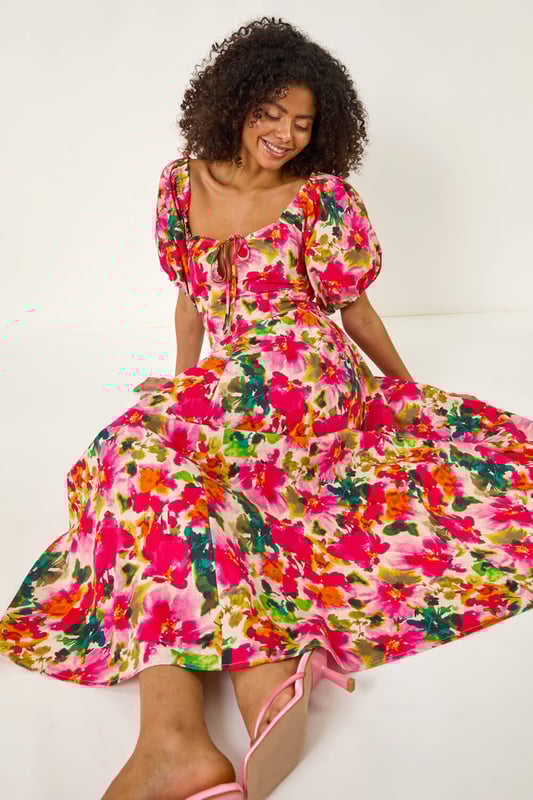 Dusk Floral Pleated Puff Dress from Roman. Feel chic and feminine in this floral puff dress, perfect for the Spring/Summer season. Featuring a flattering tie detail at the bust and cute short puff sleeves, this dress is designed in a stylish fit. Made from a comfortable woven fabric, it's a pull-on style for effortless wearing. Pair with sandals and sunglasses for a delightful outfit that's ideal for sunny days out!