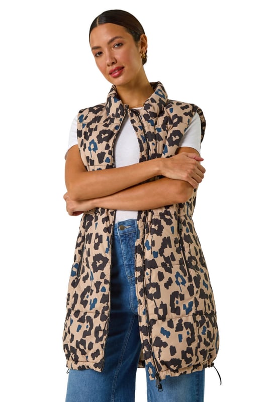 Animal Print Hooded Gilet from Roman. Stay stylish and on-trend this Spring Summer with this animal print hooded gilet in a longline silhouette. The eye-catching animal print adds a wild twist to this quilted piece, featuring a zip and practical zip pockets at the front. The gilet boasts a cosy funnel neck and a drawcord hood. Layer it over your favourite shirt and jeggings for a fashionable look that's versatile and perfect for the season!