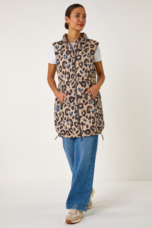 Animal Print Hooded Gilet from Roman. Stay stylish and on-trend this Spring Summer with this animal print hooded gilet in a longline silhouette. The eye-catching animal print adds a wild twist to this quilted piece, featuring a zip and practical zip pockets at the front. The gilet boasts a cosy funnel neck and a drawcord hood. Layer it over your favourite shirt and jeggings for a fashionable look that's versatile and perfect for the season!