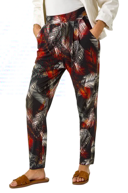 Leaf Print Harem Trouser from Roman. Embrace the tropical vibes with these leaf print harem trousers. Designed with an all over print, these trousers feature two front pockets and offer a comfortable, full-length fit. Pair with a simple cami top and sandals for a laid-back and stylish Spring/Summer look that's perfect for any casual outing!