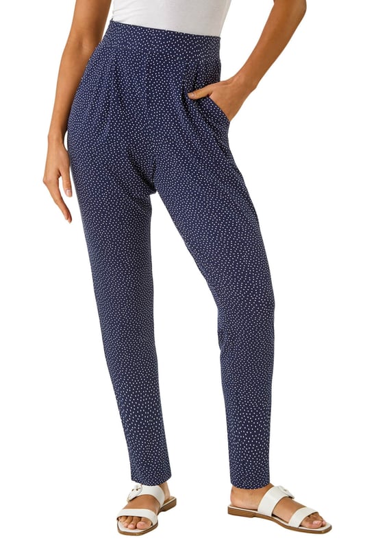 Spot Print Harem Trouser from Roman. Add a touch of fun to your wardrobe with these stylish harem spot print trousers. These full length trousers are fully printed for a statement look and include two practical pockets. Pair them with a simple t-shirt and a cosy cardigan for a chic and effortless style that's perfect for the Spring/Summer season!