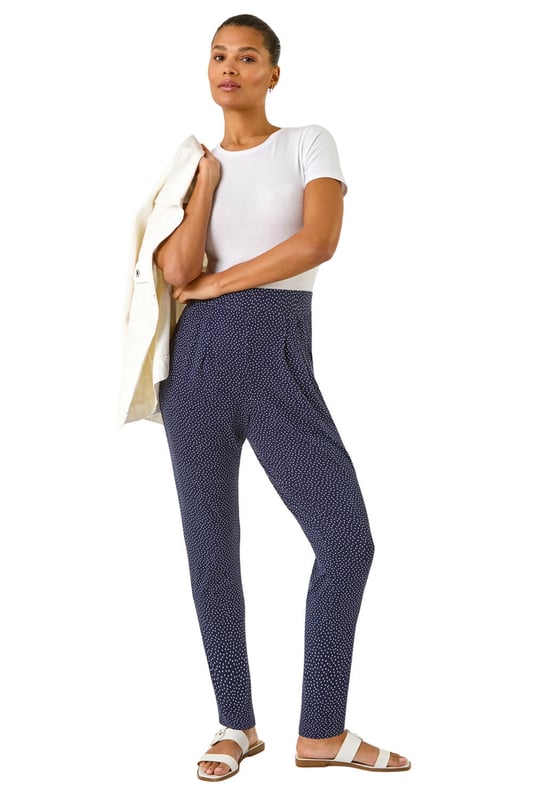 Spot Print Harem Trouser from Roman. Add a touch of fun to your wardrobe with these stylish harem spot print trousers. These full length trousers are fully printed for a statement look and include two practical pockets. Pair them with a simple t-shirt and a cosy cardigan for a chic and effortless style that's perfect for the Spring/Summer season!