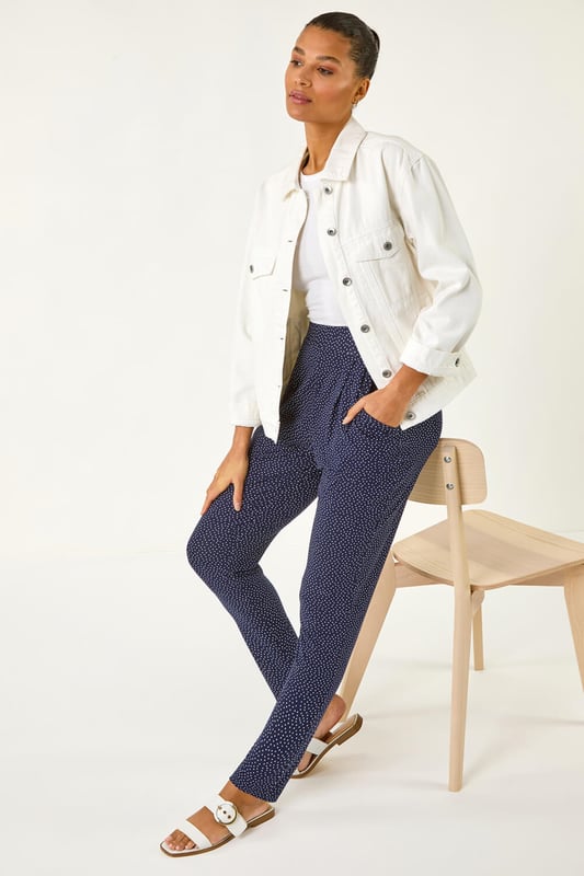 Spot Print Harem Trouser from Roman. Add a touch of fun to your wardrobe with these stylish harem spot print trousers. These full length trousers are fully printed for a statement look and include two practical pockets. Pair them with a simple t-shirt and a cosy cardigan for a chic and effortless style that's perfect for the Spring/Summer season!
