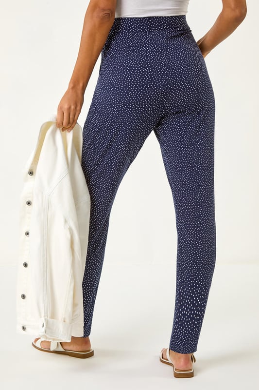 Spot Print Harem Trouser from Roman. Add a touch of fun to your wardrobe with these stylish harem spot print trousers. These full length trousers are fully printed for a statement look and include two practical pockets. Pair them with a simple t-shirt and a cosy cardigan for a chic and effortless style that's perfect for the Spring/Summer season!