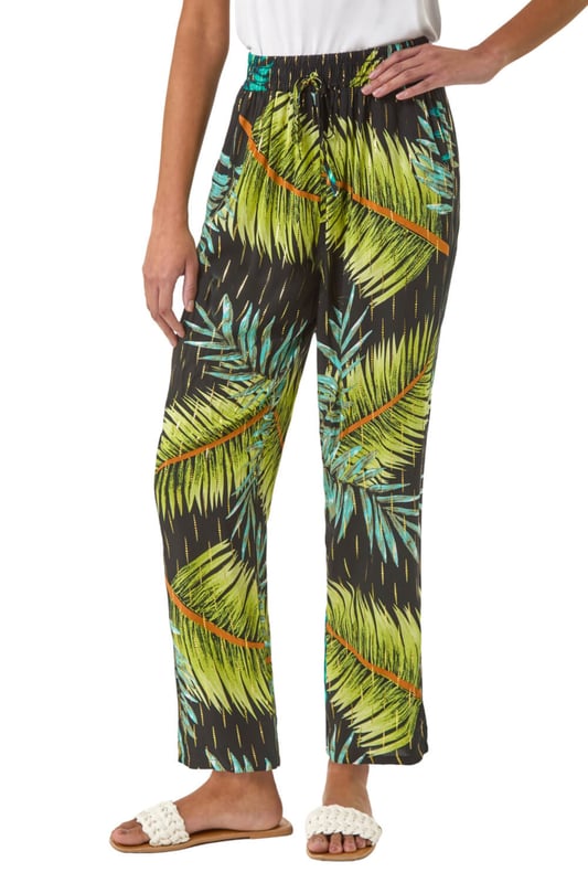 Shimmer Palm Print Harem Trouser from Roman. Elevate your wardrobe with these stylish palm shimmer harem trousers, designed for both comfort and elegance. Featuring a flattering elasticated waist with an adjustable drawcord, they offer a perfect fit while the lightweight, flowy fabric adds effortless movement. Ideal for warm-weather days and holiday escapes, pair them with a cami top and sandals for an effortlessly chic look.