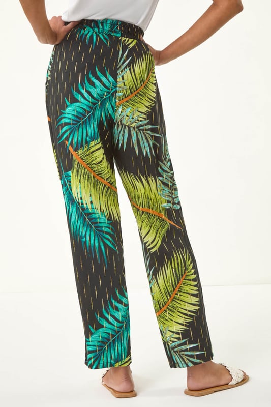 Shimmer Palm Print Harem Trouser from Roman. Elevate your wardrobe with these stylish palm shimmer harem trousers, designed for both comfort and elegance. Featuring a flattering elasticated waist with an adjustable drawcord, they offer a perfect fit while the lightweight, flowy fabric adds effortless movement. Ideal for warm-weather days and holiday escapes, pair them with a cami top and sandals for an effortlessly chic look.