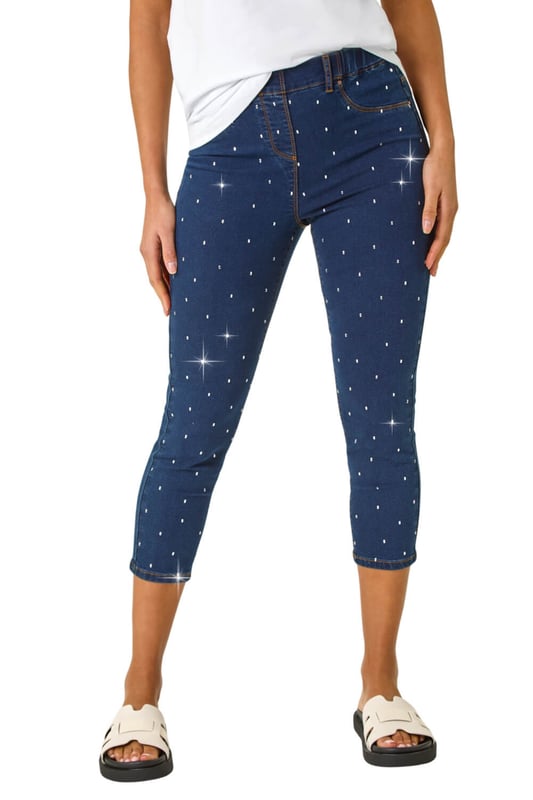 Embellished Cropped Stretch Jeggings from Roman. Get ready to sparkle in these cropped jeggings this Spring Summer! Featuring functional belt loops and a flattering shape, these denim jeggings are adorned with beautiful embellished details. Cut from a soft, stretch cotton fabric, they finish at a stylish cropped length. Pair with a white blouse and wedge sandals for a trendy outfit that effortlessly transitions from day to night.