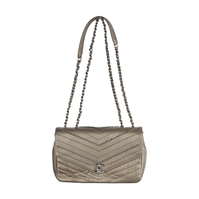 From Fall/Winter 2018 collection, the Chevron Flap Bag by Chanel is made of calfskin leather in metallic silver which gives a glittering appearance and intriguing texture. It features embelished chains woven with leather straps and tiny sequin studs that creates the Chevron pattern in the center. The shoulder strap is decorated with the woven chain as well as leather strap for the ease of carrying over the shoulder. 
Remarks: Sticker on the CC logo-ed metal clasp is still intact.
Inclusion: Dust bag, box, authentication card.
NFT option available. Discover more.
Assured Product Authenticity: This product is supplied by a renowned and trusted partner.
With this purchase, you are preserving iconic craftsmanship, celebrating heritage, and embracing the beauty of conscious shopping. Measurments:  width: 610 mm height: 381 mm