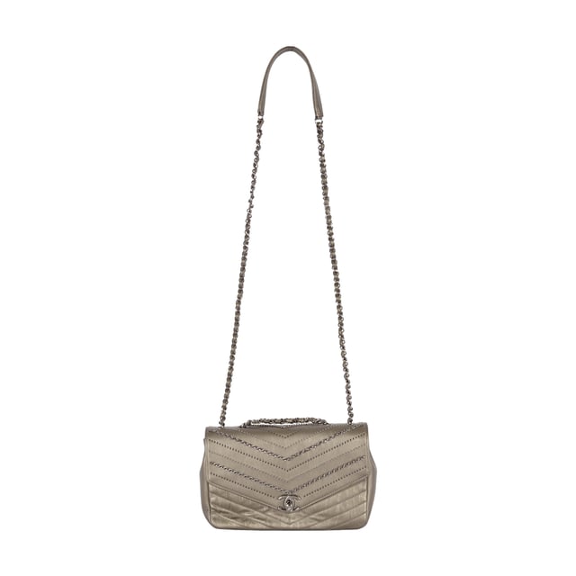 From Fall/Winter 2018 collection, the Chevron Flap Bag by Chanel is made of calfskin leather in metallic silver which gives a glittering appearance and intriguing texture. It features embelished chains woven with leather straps and tiny sequin studs that creates the Chevron pattern in the center. The shoulder strap is decorated with the woven chain as well as leather strap for the ease of carrying over the shoulder. 
Remarks: Sticker on the CC logo-ed metal clasp is still intact.
Inclusion: Dust bag, box, authentication card.
NFT option available. Discover more.
Assured Product Authenticity: This product is supplied by a renowned and trusted partner.
With this purchase, you are preserving iconic craftsmanship, celebrating heritage, and embracing the beauty of conscious shopping. Measurments:  width: 610 mm height: 381 mm
