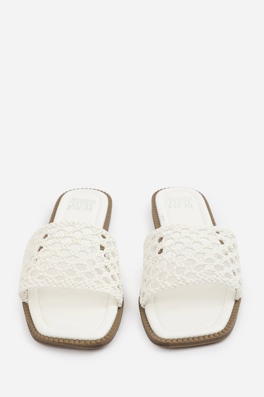 Wheres That From Womens 'Lottie' Woven Strap Flat Sandals Step into summer style with the Lottie Woven Strap Flat Sandals, crafted for both comfort and statement appeal. Featuring a metallic footbed and intricately braided upper, these sandals add a touch of luxe to any warm-weather look. Perfect for holidays, brunches, or day-to-night outfits. The open-toe, easy slip-on design makes them your go-to for effortless elegance. Key Features: • Material: Metallic faux leather with woven braided strap • Durability: Sturdy sole with cushioned footbed for all-day wear • Closure: Slip-on style for easy on and off convenience • Detail: Handcrafted-look open weave strap over a square toe base