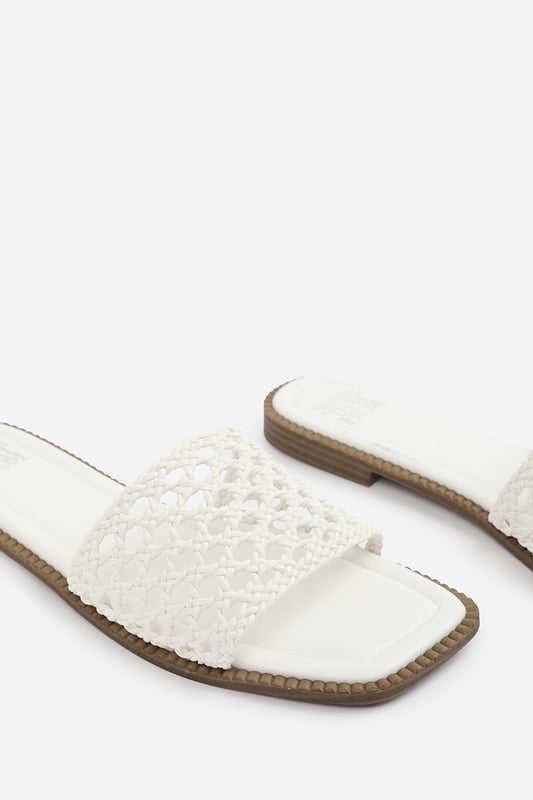 Wheres That From Womens 'Lottie' Woven Strap Flat Sandals Step into summer style with the Lottie Woven Strap Flat Sandals, crafted for both comfort and statement appeal. Featuring a metallic footbed and intricately braided upper, these sandals add a touch of luxe to any warm-weather look. Perfect for holidays, brunches, or day-to-night outfits. The open-toe, easy slip-on design makes them your go-to for effortless elegance. Key Features: • Material: Metallic faux leather with woven braided strap • Durability: Sturdy sole with cushioned footbed for all-day wear • Closure: Slip-on style for easy on and off convenience • Detail: Handcrafted-look open weave strap over a square toe base