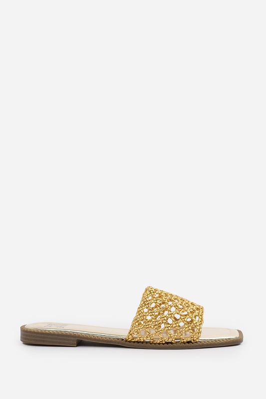 Wheres That From Womens 'Lottie' Women Strap Flat Sandals Step into summer style with the Lottie Woven Strap Flat Sandals, crafted for both comfort and statement appeal. Featuring a metallic footbed and intricately braided upper, these sandals add a touch of luxe to any warm-weather look. Perfect for holidays, brunches, or day-to-night outfits. The open-toe, easy slip-on design makes them your go-to for effortless elegance. Key Features: • Material: Metallic faux leather with woven braided strap • Durability: Sturdy sole with cushioned footbed for all-day wear • Closure: Slip-on style for easy on and off convenience • Detail: Handcrafted-look open weave strap over a square toe base