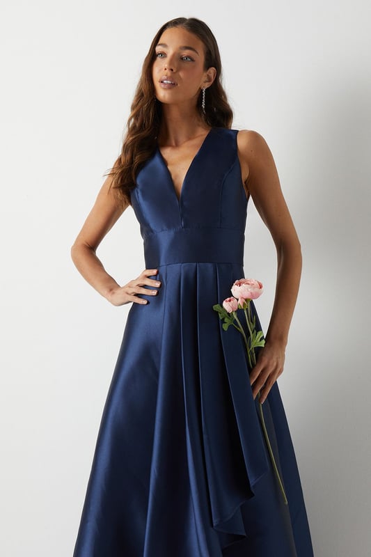 Elegant plunge neckline for a sophisticated look
        Sleeveless design perfect for warm-weather weddings
        Dramatic waterfall skirt with high-low hemline
        Fitted bodice accentuates the waistline
        Floor-sweeping maxi length for a graceful silhouette
    
    This stunning bridesmaids maxi dress from Coast is the epitome of elegance and grace. The plunging V-neckline adds a touch of allure, while the fitted bodice creates a flattering silhouette. The pice de rsistance is undoubtedly the waterfall skirt, which cascades beautifully to the floor, creating a mesmerising high-low effect. Perfect for a sophisticated bridal party, this dress will ensure you look and feel your best as you support the bride on her special day. Style with delicate strappy sandals and a sleek updo to complement the dress's clean lines. For a coordinated bridal party look, consider matching accessories such as pearl earrings or a dainty bracelet. This versatile piece will have you feeling confident and radiant as you celebrate love and new beginnings.