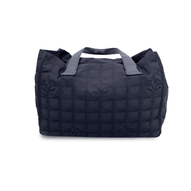 VINTAGE, RRP AS NEW
Chanel Travel Line Tote (2003-2004) - Understated Elegance in Motion  Timeless, functional, and distinctly Chanel - this black jacquard nylon tote from the house's Travel Line collection is a minimalist masterpiece from the 2003-2004 era, designed with the modern voyager in mind.  Crafted from sleek black jacquard nylon, the bag features the iconic Chanel motif subtly woven into the fabric - a quiet nod to the maison's storied heritage. The silhouette is elevated by a black leather shoulder straps/handles, offering both comfort and sophistication for life on the move.  Inside, the nylon lining holds two side zip pockets, perfect for keeping essentials within reach while maintaining the tote's clean lines. True to Chanel's legacy of craftsmanship, the interior bears the 'Chanel - Made in Italy' tag and a discreet ity hologram, grounding this vintage gem in ity and history.  Effortlessly chic and endlessly versatile, this Chanel Travel Line tote is a sophisticated companion - ideal for everyday elegance, city strolls, or quiet getaways. A rare find for collectors and lovers of early-2000s Chanel. Condition Rating: B - VERY GOOD CONDITIONCondition Details: Some wear of use on bottom corners. Some normal wear of use on leather handles. Please, look carefully at the photos and ask if you have any doubts.Measurements (cm):Depth: 11.4Height: 20.3Length: 27.9Other Details: Dustbag? NoKeys? NoBox? No Measurments:  width: 114 mm length: 279 mm height: 203 mm