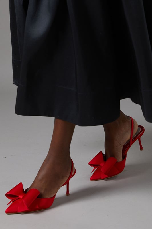 Elegant satin court shoes with a striking bow detail
        Slingback design for a secure and comfortable fit
        Medium stiletto heel measuring between 5 and 6.5cm
        Pointed toe silhouette for a sophisticated look
        Versatile style suitable for various formal occasions
    
    Step into elegance with these exquisite Lola satin court shoes from Coast. The eye-catching bow detail adorning the pointed toe adds a touch of feminine charm, while the slingback design ensures a secure fit as you glide across the dance floor. With a medium stiletto heel that strikes the perfect balance between comfort and style, these shoes are ideal for weddings, race days, or any sophisticated soire. Pair them with a flowing midi dress for a timeless ensemble, or contrast their delicate appearance with a sharply tailored suit for a modern twist. The versatility of these shoes makes them a wardrobe staple for the discerning woman who appreciates quality and style in equal measure.