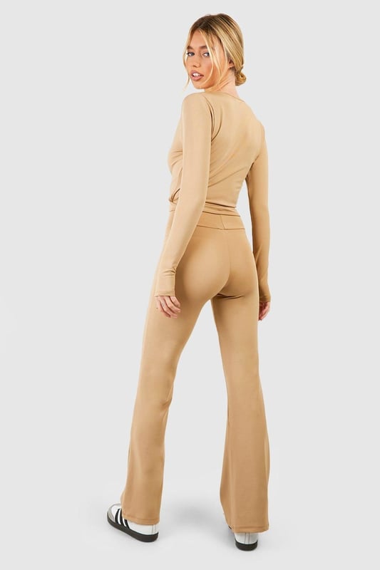 Fold-over waistband for adjustable comfort
        Flared leg design for a retro-inspired silhouette
        Woven tab detail adds a unique touch
        Stretchy fabric blend for ease of movement
        Versatile style suitable for yoga and beyond
    
    Embrace comfort and style with these flared yoga pants, perfect for your active lifestyle. The fold-over waist allows for customisable fit, while the flared leg design adds a trendy, retro-inspired flair to your workout ensemble. The woven tab detail sets these pants apart, making them a standout piece in your activewear collection. Pair with a cropped wrap top and trainers for a coordinated look that transitions seamlessly from the yoga studio to casual outings. The stretchy fabric ensures unrestricted movement during your practice, while the versatile design makes these pants suitable for various activities beyond yoga. Whether you're perfecting your downward dog or meeting friends for a post-workout brunch, these yoga pants offer the perfect blend of functionality and fashion-forward appeal.
