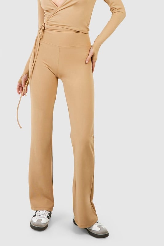 Fold-over waistband for adjustable comfort
        Flared leg design for a retro-inspired silhouette
        Woven tab detail adds a unique touch
        Stretchy fabric blend for ease of movement
        Versatile style suitable for yoga and beyond
    
    Embrace comfort and style with these flared yoga pants, perfect for your active lifestyle. The fold-over waist allows for customisable fit, while the flared leg design adds a trendy, retro-inspired flair to your workout ensemble. The woven tab detail sets these pants apart, making them a standout piece in your activewear collection. Pair with a cropped wrap top and trainers for a coordinated look that transitions seamlessly from the yoga studio to casual outings. The stretchy fabric ensures unrestricted movement during your practice, while the versatile design makes these pants suitable for various activities beyond yoga. Whether you're perfecting your downward dog or meeting friends for a post-workout brunch, these yoga pants offer the perfect blend of functionality and fashion-forward appeal.