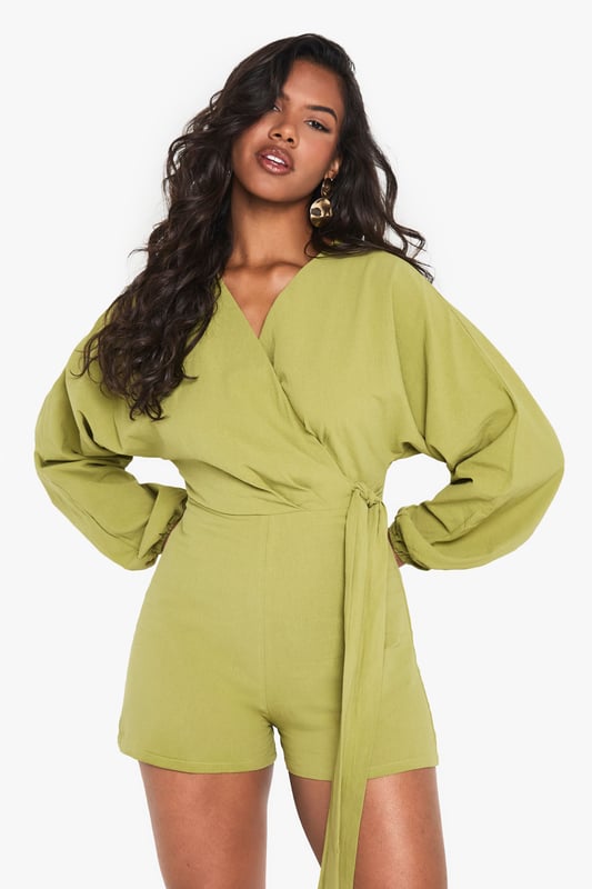 Wrap-over design with tie detail for adjustable fit
        Flattering V-neckline
        Voluminous balloon sleeves for dramatic flair
        Linen-look fabric for a breezy, textured appearance
        Versatile playsuit suitable for various casual occasions
    
    Embrace effortless chic with this wrap-over tie detail playsuit from Boohoo. The linen-look fabric offers a lightweight feel, perfect for warm-weather outings. Its striking balloon sleeves add a touch of drama to the silhouette, while the V-neckline flatters your dcolletage. Style this playsuit with strappy sandals and a woven bag for a laid-back brunch with friends. For family gatherings, pair it with white trainers and delicate gold jewellery. The adjustable tie allows you to customise the fit, making it a versatile piece for your wardrobe. Whether you're heading to a casual garden party or a day out shopping, this playsuit offers both comfort and style. Its relaxed yet put-together look makes it an ideal choice for those who want to stay on-trend without compromising on ease.