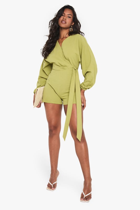 Wrap-over design with tie detail for adjustable fit
        Flattering V-neckline
        Voluminous balloon sleeves for dramatic flair
        Linen-look fabric for a breezy, textured appearance
        Versatile playsuit suitable for various casual occasions
    
    Embrace effortless chic with this wrap-over tie detail playsuit from Boohoo. The linen-look fabric offers a lightweight feel, perfect for warm-weather outings. Its striking balloon sleeves add a touch of drama to the silhouette, while the V-neckline flatters your dcolletage. Style this playsuit with strappy sandals and a woven bag for a laid-back brunch with friends. For family gatherings, pair it with white trainers and delicate gold jewellery. The adjustable tie allows you to customise the fit, making it a versatile piece for your wardrobe. Whether you're heading to a casual garden party or a day out shopping, this playsuit offers both comfort and style. Its relaxed yet put-together look makes it an ideal choice for those who want to stay on-trend without compromising on ease.