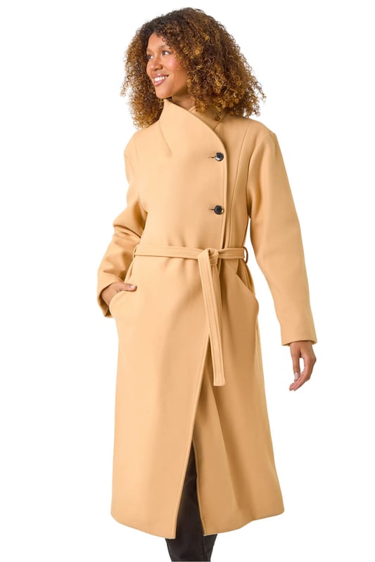Asymmetric Double Breasted Tie Waist Coat from Roman. Wrap up in style this Autumn Winter with our fashionable, asymmetric double breasted coat. The unique asymmetric front and contrasting button fastenings add a modern touch to this classic coat silhouette. Featuring a tie waist belt detail for a flattering cinched-in look, this coat is crafted from a comfy woven fabric and fully lined for extra warmth. Finished with angled side pockets and long raglan sleeves, this coat is a must-have for your cold weather wardrobe. Pair with your favourite knit and ankle boots for a complete look!