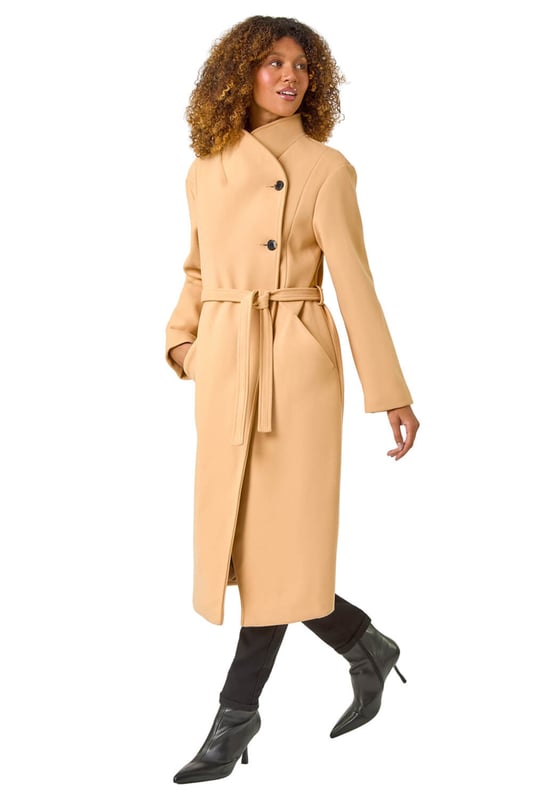 Asymmetric Double Breasted Tie Waist Coat from Roman. Wrap up in style this Autumn Winter with our fashionable, asymmetric double breasted coat. The unique asymmetric front and contrasting button fastenings add a modern touch to this classic coat silhouette. Featuring a tie waist belt detail for a flattering cinched-in look, this coat is crafted from a comfy woven fabric and fully lined for extra warmth. Finished with angled side pockets and long raglan sleeves, this coat is a must-have for your cold weather wardrobe. Pair with your favourite knit and ankle boots for a complete look!