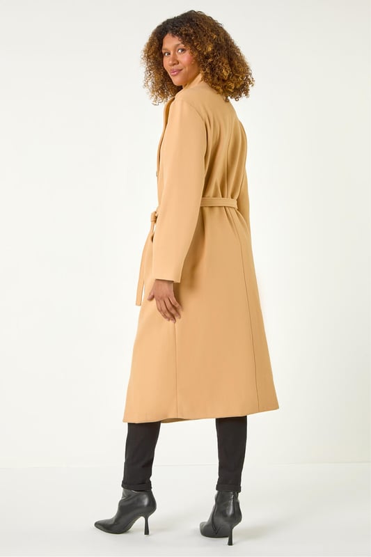 Asymmetric Double Breasted Tie Waist Coat from Roman. Wrap up in style this Autumn Winter with our fashionable, asymmetric double breasted coat. The unique asymmetric front and contrasting button fastenings add a modern touch to this classic coat silhouette. Featuring a tie waist belt detail for a flattering cinched-in look, this coat is crafted from a comfy woven fabric and fully lined for extra warmth. Finished with angled side pockets and long raglan sleeves, this coat is a must-have for your cold weather wardrobe. Pair with your favourite knit and ankle boots for a complete look!