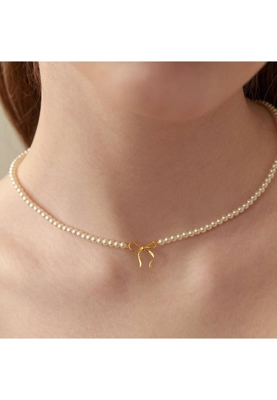 Piezas: 1 pieza  
Material: Perla sintética cobre bañado en oro de 14K  
Instrucciones de cuidado: Evite usar durante el ejercicio, ya que el sudor reaccionará con la joyería produciendo cloruro de plata y sulfuro de cobre, lo que causa el deterioro y corrosión de la joyería con el tiempo.  
Importado  
Medidas del producto (medidas en pulgadas) y conversión de tallas  
Longitud del colgante: 0.6 pulgadas  
Ancho del colgante: 0.5 pulgadas  
Longitud de la cadena: 15 pulgadas