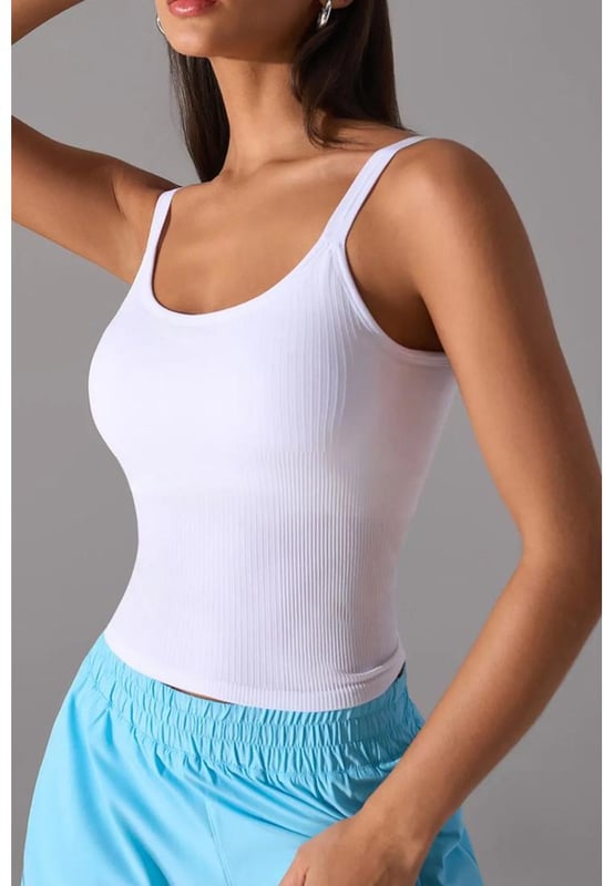 Top sin mangas de estilo básico  
  Estiramiento moderado para mayor comodidad  
  69% nailon, 21% poliéster, 10% spandex  
  Lavar a máquina en frío, secar a baja temperatura  
  Importado  
  Almohadillas de pecho desmontables para un soporte personalizable  
  Disponible en tallas del 4 al 12  
Material: Tejido acanalado