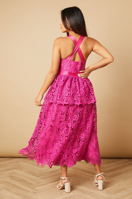 Elegant cross strap halterneck design with a feminine square neckline
        Intricate all-over lace detailing creates a romantic texture
        Tiered midi skirt with three distinct layers for added movement
        Flattering waistband accentuates the silhouette
        Cross-back straps add a striking detail to the rear view
    
    This enchanting Oasis midi dress showcases delicate lace craftsmanship throughout, making it perfect for special occasions. The distinctive cross strap design creates a flattering halterneck that frames the dcolletage beautifully, whilst the tiered skirt adds playful movement with every step. Style with strappy heeled sandals as shown for garden parties or summer weddings, or dress up with statement earrings and an elegant clutch for formal events. The midi length offers versatility for various social gatherings, from race day to graduation ceremonies. For cooler evenings, layer with a lightweight wrap or tailored blazer to maintain the dress's feminine silhouette. This piece works wonderfully for those seeking a balance between sophisticated charm and romantic flair.