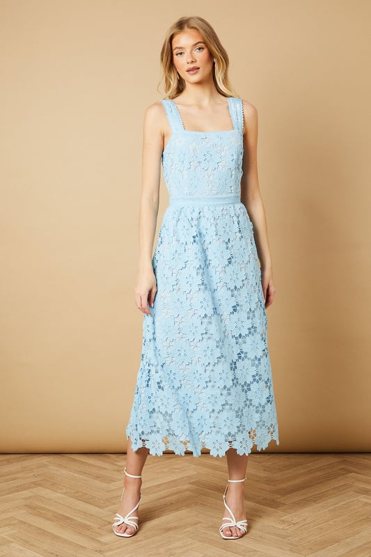 Elegant square neckline with delicate floral lace detailing throughout
        Wide shoulder straps with scalloped lace trim for added feminine charm
        Fitted bodice with defined waistband creating a flattering silhouette
        Midi-length design with intricate all-over floral lace pattern
        A-line skirt that gracefully falls to mid-calf length
    
    This enchanting Oasis midi dress showcases exquisite floral lace detailing that makes it perfect for special occasions. The square neckline frames the dcolletage beautifully, while the defined waistband accentuates your natural curves. Style with strappy heeled sandals and statement earrings, as shown on our model, for weddings or formal garden parties. For race day events, pair with a fascinator and clutch bag for a sophisticated ensemble. The versatile midi length works wonderfully for both daytime celebrations and evening soires. This dress can be styled differently with a tailored blazer and court shoes for graduation ceremonies or paired with delicate jewellery for elegant dinner dates. Machine washable for convenient care, this dress combines timeless femininity with practical wearability.