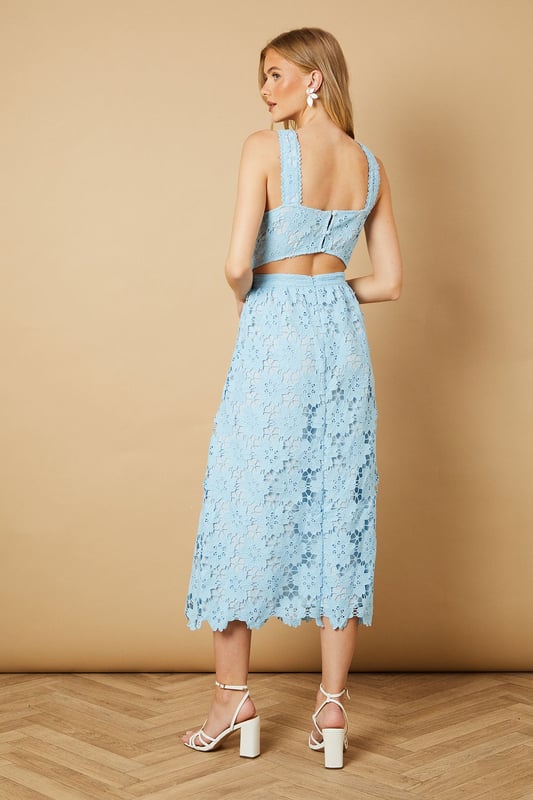 Elegant square neckline with delicate floral lace detailing throughout
        Wide shoulder straps with scalloped lace trim for added feminine charm
        Fitted bodice with defined waistband creating a flattering silhouette
        Midi-length design with intricate all-over floral lace pattern
        A-line skirt that gracefully falls to mid-calf length
    
    This enchanting Oasis midi dress showcases exquisite floral lace detailing that makes it perfect for special occasions. The square neckline frames the dcolletage beautifully, while the defined waistband accentuates your natural curves. Style with strappy heeled sandals and statement earrings, as shown on our model, for weddings or formal garden parties. For race day events, pair with a fascinator and clutch bag for a sophisticated ensemble. The versatile midi length works wonderfully for both daytime celebrations and evening soires. This dress can be styled differently with a tailored blazer and court shoes for graduation ceremonies or paired with delicate jewellery for elegant dinner dates. Machine washable for convenient care, this dress combines timeless femininity with practical wearability.