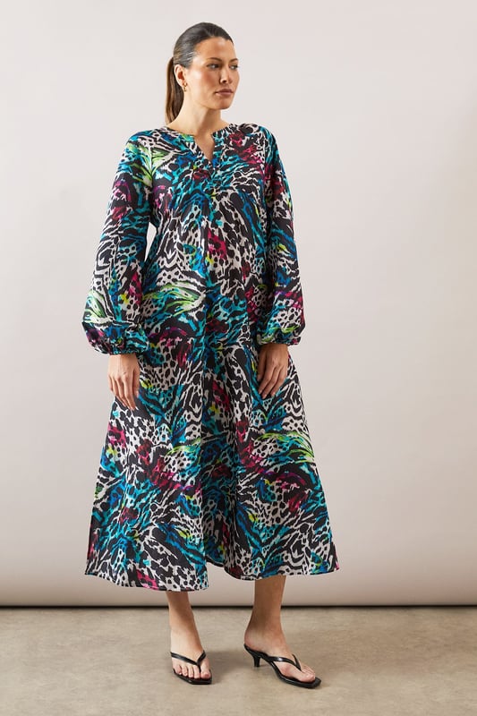 Collarless midaxi dress featuring a striking zebra print pattern with vibrant hues
        Elegant crew neckline with subtle split detail for a refined touch
        Voluminous balloon sleeves create a dramatic silhouette
        Relaxed, flowing fit through the body for all-day comfort
        Midaxi length offers versatile styling options for various occasions
    
    Make a statement with this eye-catching Wallis zebra print midaxi dress. The relaxed silhouette combines sophistication with comfort, making it perfect for daytime engagements. Style with flat sandals as shown for family gatherings or weekend brunches, or pair with a sleek ponytail and minimal jewellery for a more polished look. The balloon sleeves add a contemporary touch to this wearable piece, while the midaxi length offers flattering coverage. Layer with a cropped denim jacket for casual outings or add a structured blazer for lunch dates. This versatile dress transitions effortlessly from shopping trips to casual meet-ups with friends, embodying the sophisticated yet comfortable aesthetic that Wallis is known for.