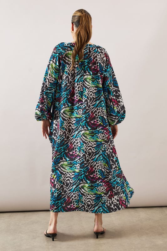 Collarless midaxi dress featuring a striking zebra print pattern with vibrant hues
        Elegant crew neckline with subtle split detail for a refined touch
        Voluminous balloon sleeves create a dramatic silhouette
        Relaxed, flowing fit through the body for all-day comfort
        Midaxi length offers versatile styling options for various occasions
    
    Make a statement with this eye-catching Wallis zebra print midaxi dress. The relaxed silhouette combines sophistication with comfort, making it perfect for daytime engagements. Style with flat sandals as shown for family gatherings or weekend brunches, or pair with a sleek ponytail and minimal jewellery for a more polished look. The balloon sleeves add a contemporary touch to this wearable piece, while the midaxi length offers flattering coverage. Layer with a cropped denim jacket for casual outings or add a structured blazer for lunch dates. This versatile dress transitions effortlessly from shopping trips to casual meet-ups with friends, embodying the sophisticated yet comfortable aesthetic that Wallis is known for.
