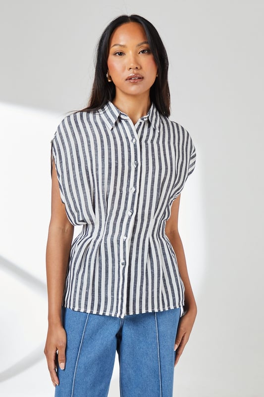 Crafted from a breathable cotton-linen blend for exceptional comfort in warm weather
        Distinctive pleat detail creates a flattering cinched waist silhouette
        Relaxed cap sleeves offer effortless movement and contemporary styling
        Classic button-through design with smart collar for versatile styling options
        Timeless stripe pattern adds visual interest to this wardrobe essential
    
    This Principles striped shirt combines casual comfort with refined detailing for everyday sophistication. The pleated waist creates a feminine silhouette that flatters your figure without sacrificing comfort. Style with wide-leg denim trousers as shown for a balanced daytime look perfect for weekend brunches or casual gatherings. For a more polished appearance, tuck the front into tailored linen trousers and add leather sandals. The cotton-linen fabric ensures breathability during warmer months whilst maintaining structure throughout the day. This versatile piece transitions effortlessly from office to outdoor caf, making it an indispensable addition to your casual wardrobe. Accessorise with simple gold-toned jewellery to complement the classic nautical-inspired pattern for family gatherings or informal social events.