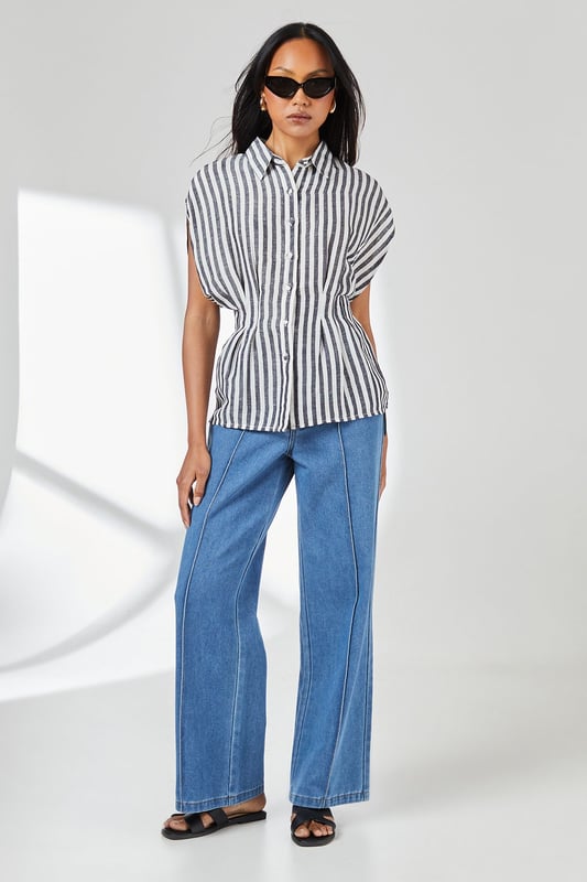 Crafted from a breathable cotton-linen blend for exceptional comfort in warm weather
        Distinctive pleat detail creates a flattering cinched waist silhouette
        Relaxed cap sleeves offer effortless movement and contemporary styling
        Classic button-through design with smart collar for versatile styling options
        Timeless stripe pattern adds visual interest to this wardrobe essential
    
    This Principles striped shirt combines casual comfort with refined detailing for everyday sophistication. The pleated waist creates a feminine silhouette that flatters your figure without sacrificing comfort. Style with wide-leg denim trousers as shown for a balanced daytime look perfect for weekend brunches or casual gatherings. For a more polished appearance, tuck the front into tailored linen trousers and add leather sandals. The cotton-linen fabric ensures breathability during warmer months whilst maintaining structure throughout the day. This versatile piece transitions effortlessly from office to outdoor caf, making it an indispensable addition to your casual wardrobe. Accessorise with simple gold-toned jewellery to complement the classic nautical-inspired pattern for family gatherings or informal social events.