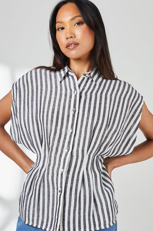 Crafted from a breathable cotton-linen blend for exceptional comfort in warm weather
        Distinctive pleat detail creates a flattering cinched waist silhouette
        Relaxed cap sleeves offer effortless movement and contemporary styling
        Classic button-through design with smart collar for versatile styling options
        Timeless stripe pattern adds visual interest to this wardrobe essential
    
    This Principles striped shirt combines casual comfort with refined detailing for everyday sophistication. The pleated waist creates a feminine silhouette that flatters your figure without sacrificing comfort. Style with wide-leg denim trousers as shown for a balanced daytime look perfect for weekend brunches or casual gatherings. For a more polished appearance, tuck the front into tailored linen trousers and add leather sandals. The cotton-linen fabric ensures breathability during warmer months whilst maintaining structure throughout the day. This versatile piece transitions effortlessly from office to outdoor caf, making it an indispensable addition to your casual wardrobe. Accessorise with simple gold-toned jewellery to complement the classic nautical-inspired pattern for family gatherings or informal social events.
