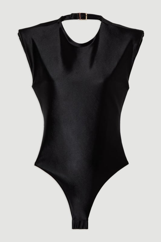 Make a statement poolside with this Wet Look Power Shoulder Cut Out Swimsuit. The architectural power shoulders create a bold, fashion-forward silhouette that commands attention, whilst the strategic cut-out detail adds intrigue to this one-piece design. Perfect for lounging by the pool at exclusive resorts or enjoying sunny beach days, this swimsuit transitions effortlessly from daytime swimming to sunset cocktails when paired with a flowing maxi skirt and statement jewellery. The sleek wet look fabric hugs your curves in all the right places, offering both style and comfort for your summer getaways.   Wet look finish catches the light. Bold power shoulder design Sleek cut-out detail Crew neckline offers coverage High-cut design elongates your figure