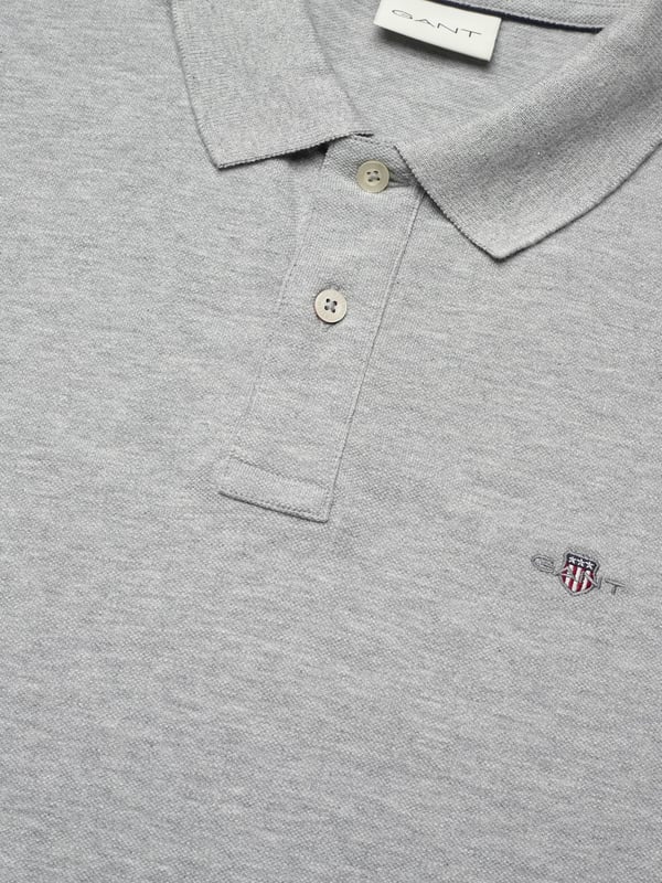 Het Gant herenpoloshirt verenigt tijdloze elegantie met sportieve nonchalance. De klassieke polokraag en de korte knoopsluiting geven het een stijlvolle uitstraling. Gemaakt van hoogwaardige materialen, biedt het een aangenaam draagcomfort de hele dag. De kleine, subtiele logostik op de borst voegt een elegante accent toe. Zijsplitten zorgen voor een optimale pasvorm en bewegingsvrijheid. Perfect voor vrije tijd en kantoor - dit poloshirt past bij elke gelegenheid. Het hoge draagcomfort maakt het een onmisbaar basic voor elke garderobe.