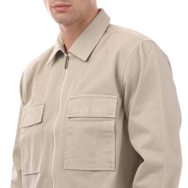 Mens Hugo Boss Lovel Zipped Overshirt in beige.- Classic collar.- Long sleeves.- Soft twill with embroidered branding on the pocket.- Branded button fastening cuffs.- Woven orange locker loop on the interior neckline.- Oversized fit.- 100% Cotton.- Ref: 50520107271