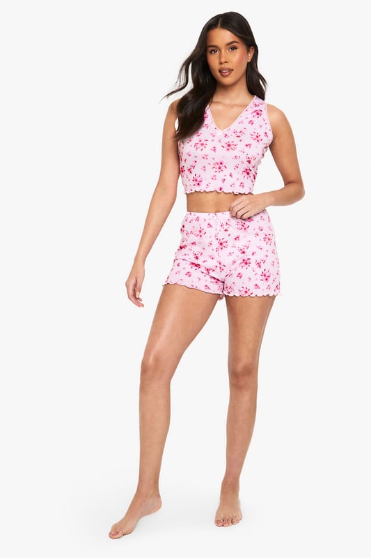Charming floral print pyjama set
        Delicate lace trim detailing
        Sleeveless crop top with V-neckline
        Matching shorts with scalloped hem
        Comfortable and stylish two-piece design
    
    Drift off to dreamland in style with this enchanting floral pyjama set from Boohoo. The sleeveless crop top features a flattering V-neckline adorned with delicate lace trim, while the matching shorts boast a charming scalloped hem. Perfect for warm summer nights or cosy evenings in, this set combines comfort with a touch of feminine flair. Layer with a soft dressing gown for those chilly mornings, or pair the top with your favourite lounge trousers for a mix-and-match look. Whether you're having a pamper night in or a girly sleepover, this versatile set will ensure you look and feel fabulous even as you slumber.