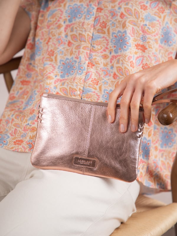 Compact, stylish, and effortlessly functional, the Tarnly purse pouch is designed for everyday ease. Crafted from supple leather, it features a refined front logo emboss and whipstitch detailing along the sides for a touch of artisanal charm. The zip-top closure is finished with a sleek leather wrist strap, making it perfect for carrying solo or slipping into a larger bag. Inside, a satin-lined interior offers thoughtful organisation with a slip pocket and three card slots, while built-in RFID protection keeps your essentials secure.&nbsp;