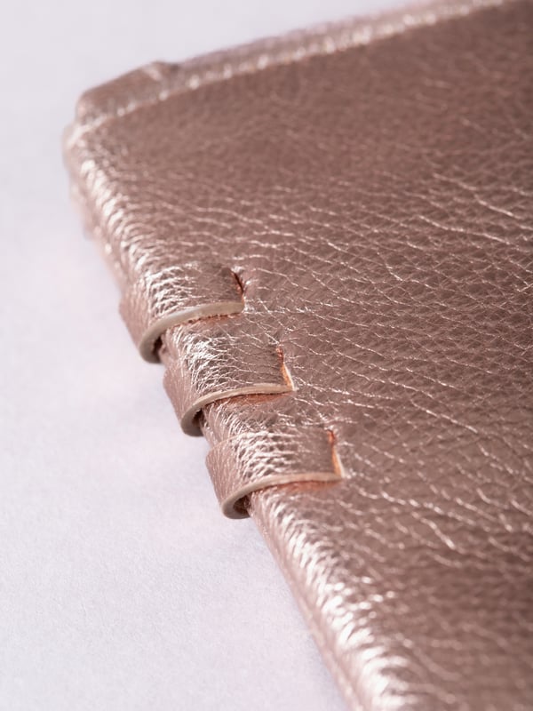 Compact, stylish, and effortlessly functional, the Tarnly purse pouch is designed for everyday ease. Crafted from supple leather, it features a refined front logo emboss and whipstitch detailing along the sides for a touch of artisanal charm. The zip-top closure is finished with a sleek leather wrist strap, making it perfect for carrying solo or slipping into a larger bag. Inside, a satin-lined interior offers thoughtful organisation with a slip pocket and three card slots, while built-in RFID protection keeps your essentials secure.&nbsp;