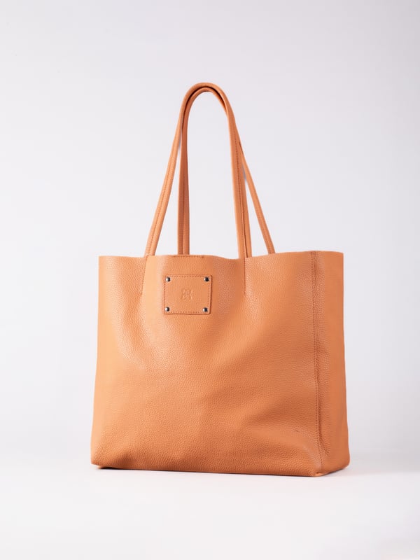 For relaxed leather luxury, look no further than the Tarn Bucket Bag in fresh apricot. This spacious tote style bag will effortlessly take you through the working week into the weekend with plenty of room for a laptop and notebooks or shopping if you&rsquo;re hitting the high street.
Crafted from real leather in a contemporary slouchy design, this bucket bag is fitted with a popper fastened top and conceals a handy inner cloth bag with zip top opening to keep your valuables extra safe. This cloth bag is securely clipped to a leather strap and is removable for ultimate versatility.