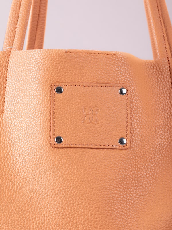 For relaxed leather luxury, look no further than the Tarn Bucket Bag in fresh apricot. This spacious tote style bag will effortlessly take you through the working week into the weekend with plenty of room for a laptop and notebooks or shopping if you&rsquo;re hitting the high street.
Crafted from real leather in a contemporary slouchy design, this bucket bag is fitted with a popper fastened top and conceals a handy inner cloth bag with zip top opening to keep your valuables extra safe. This cloth bag is securely clipped to a leather strap and is removable for ultimate versatility.