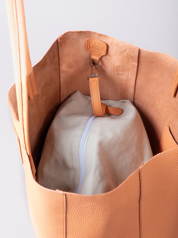 For relaxed leather luxury, look no further than the Tarn Bucket Bag in fresh apricot. This spacious tote style bag will effortlessly take you through the working week into the weekend with plenty of room for a laptop and notebooks or shopping if you&rsquo;re hitting the high street.
Crafted from real leather in a contemporary slouchy design, this bucket bag is fitted with a popper fastened top and conceals a handy inner cloth bag with zip top opening to keep your valuables extra safe. This cloth bag is securely clipped to a leather strap and is removable for ultimate versatility.