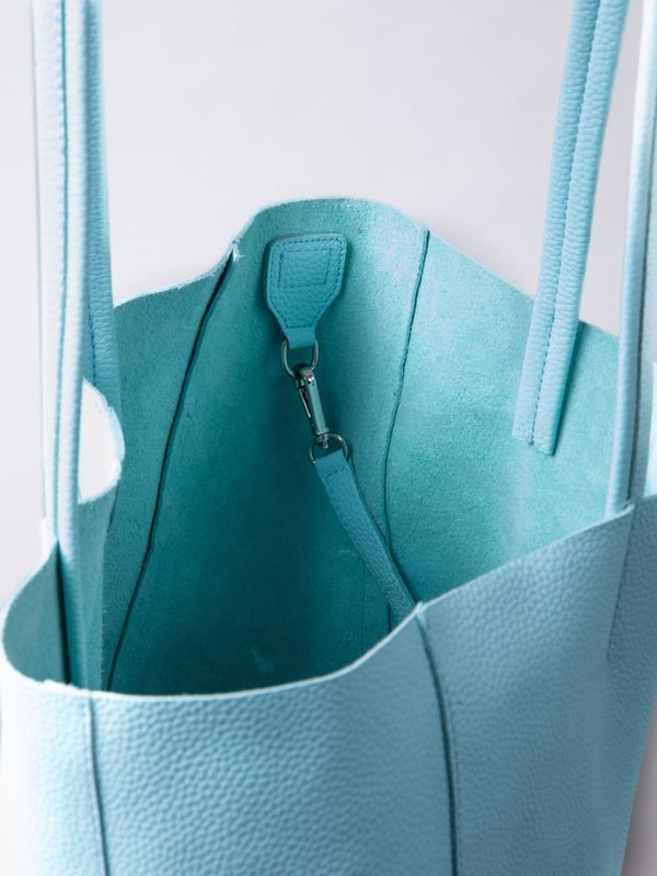 For relaxed leather luxury, look no further than the Tarn Bucket Bag in pretty turquoise. This spacious tote style bag will effortlessly take you through the working week into the weekend with plenty of room for a laptop and notebooks or shopping if you&rsquo;re hitting the high street.
Crafted from real leather in a contemporary slouchy design, this bucket bag is fitted with a popper fastened top and conceals a handy inner cloth bag with zip top opening to keep your valuables extra safe. This cloth bag is securely clipped to a leather strap and is removable for ultimate versatility.