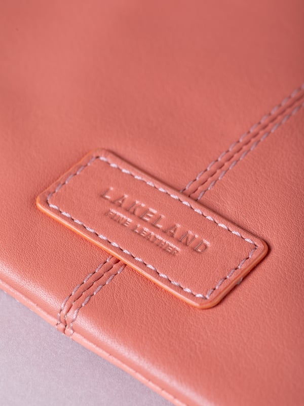 Compact, stylish, and effortlessly functional, the Tarnly purse pouch is designed for everyday ease. Crafted from supple leather, it features a refined front logo emboss and whipstitch detailing along the sides for a touch of artisanal charm. The zip-top closure is finished with a sleek leather wrist strap, making it perfect for carrying solo or slipping into a larger bag. Inside, a satin-lined interior offers thoughtful organisation with a slip pocket and three card slots, while built-in RFID protection keeps your essentials secure.&nbsp;