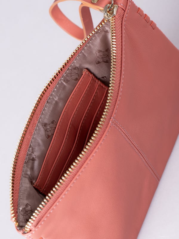 Compact, stylish, and effortlessly functional, the Tarnly purse pouch is designed for everyday ease. Crafted from supple leather, it features a refined front logo emboss and whipstitch detailing along the sides for a touch of artisanal charm. The zip-top closure is finished with a sleek leather wrist strap, making it perfect for carrying solo or slipping into a larger bag. Inside, a satin-lined interior offers thoughtful organisation with a slip pocket and three card slots, while built-in RFID protection keeps your essentials secure.&nbsp;