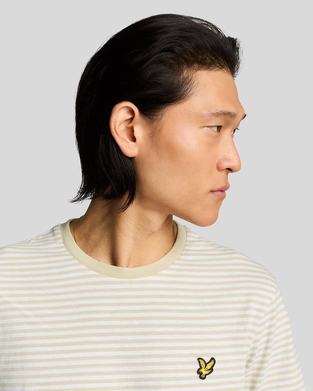 Erweitern Sie Ihre Freizeitgarderobe mit dem T-Shirt mit bretonischen Streifen aus Leinenmischung, einem unverzichtbaren Stück aus unserer Legacy-Reihe. Dieses kurzärmelige Basic vereint auf harmonische Weise exquisite Handwerkskunst und zeitloses Design und ist damit die perfekte Ergänzung für die Kollektion jedes anspruchsvollen Gentlemans. - Zusammensetzung: 80 % Baumwolle, 20 % Leinen für atmungsaktiven Tragekomfort - Passform: Normal geschnitten, für eine schmeichelhafte Silhouette - Logo-Branding: Eleganter goldener gestickter Adler - Platzierung: Linke Brust, für einen Hauch von Raffinesse - Vielseitiges Styling: Lässt sich nahtlos mit Cargohosen oder Shorts kombinieren für mühelose Eleganz  Erweitern Sie Ihre Frühlingskollektion für Herren mit diesem edlen T-Shirt, bei dem Luxus auf Vielseitigkeit trifft.
