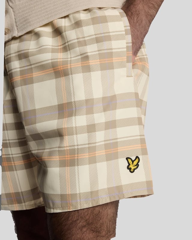 Introducing the Tartan Resort Swim Shorts, an exquisite addition to our spring menswear collection. Meticulously crafted from 100% premium polyester, these shorts embody sophistication and comfort, featuring a ribbed waistband with a drawcord for a personalized fit and inset side pockets for practicality. Completed with a distinguished golden embroidered eagle logo on the bottom leg, these swim shorts effortlessly blend style with functionality for the discerning gentleman.

- Material: 100% Polyester
- Fit: Regular
- Features: Ribbed waist band, drawcord, inset side pockets
- Logo: Golden embroidered eagle
- Versatile styling for resort transitions

Elevate your swimwear repertoire with the Tartan Resort Swim Shorts, a refined choice for the discerning gentleman this spring.